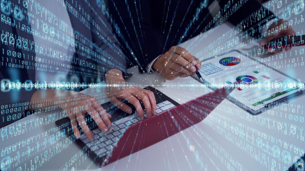 Business professionals analyzing digital financial data and charts on a tablet and laptop, symbolizing Manufacturing Finance Transformation through technology and automation with Microsoft Dynamics 365 Business Central.