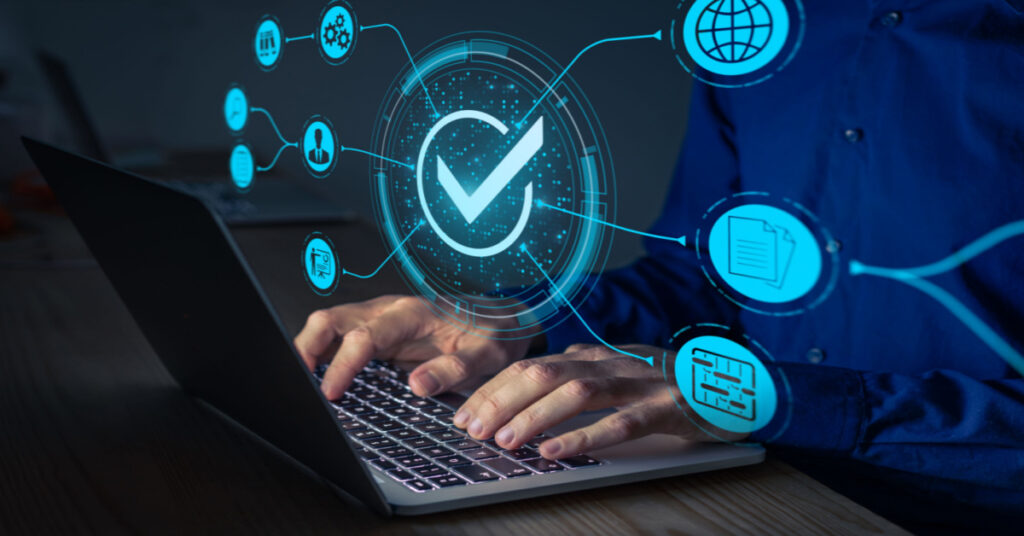 Manufacturing Compliance with international norms and laws. The concept involves a QA and compliance management consultant working on a computer.