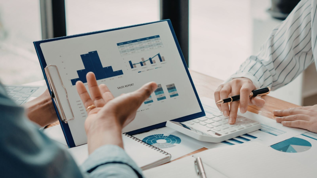 Professionals reviewing financial reports, charts, and calculator data to analyze performance and support business decisions